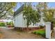 Property exterior with brick foundation, white stucco, manicured landscaping, and nearby parking at 10 Logan St # 6, Charleston, SC 29401