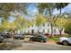 Street view of multi-story home with mature landscaping, black iron fence, and ample street parking at 10 Logan St # 6, Charleston, SC 29401