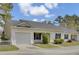 Charming exterior view with one-car garage, tidy landscaping, and classic white siding under a cloudy blue sky at 100 Bridgetown Rd # 10B, Goose Creek, SC 29445