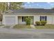 Front exterior showcasing a one-car garage, neutral siding, tidy landscaping and an inviting entryway at 100 Bridgetown Rd # 10B, Goose Creek, SC 29445