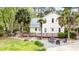 Scenic backyard with deck, gravel area, a three car garage, and mature trees at 1034 Orangeburg Rd, Summerville, SC 29483