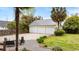 View of a three-car garage from a patio with fire pit and seating in a landscaped backyard at 1034 Orangeburg Rd, Summerville, SC 29483