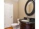 Updated bathroom features a dark granite countertop with a wooden vanity and a framed oval mirror at 1034 Orangeburg Rd, Summerville, SC 29483