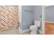 Bathroom with blue walls, gray tile floors, and a colorful shower curtain at 1034 Orangeburg Rd, Summerville, SC 29483