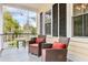 Inviting front porch featuring comfortable seating with red cushions and a peaceful outdoor ambiance at 1034 Orangeburg Rd, Summerville, SC 29483