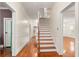 Bright hallway with hardwood floors, staircase, and white wainscoting, creating a welcoming entrance at 1034 Orangeburg Rd, Summerville, SC 29483
