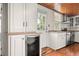 Bright kitchen features white cabinets, stainless steel appliances, wood ceiling, and view to the backyard at 1034 Orangeburg Rd, Summerville, SC 29483