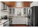 Well-lit kitchen with stainless steel appliances, white cabinets, and charming wood ceiling at 1034 Orangeburg Rd, Summerville, SC 29483