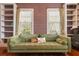 Cozy living room with green velvet sofa, built-in bookshelves, and wood floors, perfect for relaxing at 1034 Orangeburg Rd, Summerville, SC 29483