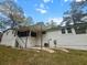 Rear view of white brick home with a covered patio, exterior door, and a well-kept lawn at 107 Woodland Dr, Summerville, SC 29485