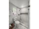 Modern bathroom with marble walk-in shower and sleek fixtures, complemented by a bright window and white horizontal paneling at 107 Woodland Dr, Summerville, SC 29485