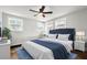 Bright bedroom showcasing a plush blue headboard, soft white bedding, and natural light from three windows at 107 Woodland Dr, Summerville, SC 29485