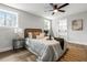 Airy bedroom showcasing light wood floors, a ceiling fan, and a comfortable bed with many windows at 107 Woodland Dr, Summerville, SC 29485