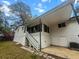 Unique two-story home features a covered porch, white painted brick and siding, and stairs to upper levels at 107 Woodland Dr, Summerville, SC 29485
