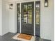 Charming front door with glass panels, sidelights, and a welcoming 