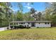 Inviting white brick home featuring a covered porch and well-maintained front lawn at 107 Woodland Dr, Summerville, SC 29485