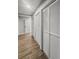 Hallway features wood floors and a series of white louvered doors for ample closet space at 107 Woodland Dr, Summerville, SC 29485