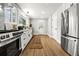 Bright kitchen with stainless steel appliances, wood floor, white cabinets, and a view of nature at 107 Woodland Dr, Summerville, SC 29485
