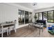 Relaxing screened porch features comfortable seating, a ceiling fan, and scenic views of the surrounding greenery at 107 Woodland Dr, Summerville, SC 29485