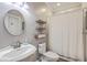 Neutral-toned bathroom featuring a white vanity sink, round mirror, and toilet at 1115 Barfield St, Charleston, SC 29492