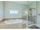 Bright bathroom with a soaking tub under a window and a glass-enclosed shower at 1115 Barfield St, Charleston, SC 29492