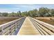 A picturesque wooden boardwalk extends over a marsh, lined with natural vegetation at 1115 Barfield St, Charleston, SC 29492