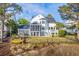 Rear view of a two-story home featuring screened porch, decks, and fenced yard overlooking the water at 1115 Barfield St, Charleston, SC 29492