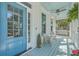 Charming front porch featuring a swing, ceiling fan, wicker chairs and vibrant blue door at 1115 Barfield St, Charleston, SC 29492
