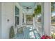 Charming front porch featuring a swing, ceiling fan, wicker chairs and a vibrant blue ceiling and door at 1115 Barfield St, Charleston, SC 29492