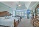 Spacious main bedroom with sitting area, tray ceiling, mounted TV, and natural light at 1115 Barfield St, Charleston, SC 29492