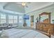 Bright main bedroom featuring sitting area, tray ceiling, mounted TV, and natural light at 1115 Barfield St, Charleston, SC 29492