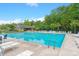 Large community pool surrounded by lounge chairs and lush green trees on a sunny day at 112 Tin Can Aly, Summerville, SC 29483