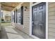 Inviting front porch with dark wood door, black shutters, and elegant lighting at 112 Tin Can Aly, Summerville, SC 29483