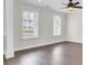 Spacious living room with dark wood floors, large windows, and a ceiling fan at 112 Tin Can Aly, Summerville, SC 29483