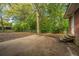 Backyard featuring a large concrete patio, mature trees, and a brick exterior at 1121 Inverness Ln, Hanahan, SC 29410