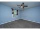 Bedroom featuring a ceiling fan, gray walls, small window with brown curtains, and gray carpet at 1121 Inverness Ln, Hanahan, SC 29410