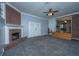 Bright living room features a brick fireplace, ceiling fan, gray walls, and gray carpet at 1121 Inverness Ln, Hanahan, SC 29410
