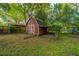Backyard featuring a wooden shed surrounded by lush greenery and trees at 1121 Inverness Ln, Hanahan, SC 29410