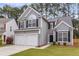 Inviting home exterior with two-car garage, manicured lawn, and classic design elements at 1158 Peninsula Cove Dr, Charleston, SC 29492