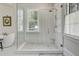 Bright bathroom featuring a glass-enclosed shower with a tile surround and brass fixtures at 1300 S Main St, Summerville, SC 29483