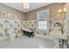 Elegant bathroom featuring a clawfoot tub, pedestal sink, black and white tiled floors and lovely floral wallpaper at 1300 S Main St, Summerville, SC 29483