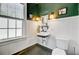 Charming bathroom with white wainscoting, contrasting dark green walls, and vintage-style fixtures at 1300 S Main St, Summerville, SC 29483