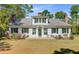 Charming two-story home with white siding, black shutters, mature trees, and manicured lawn at 1300 S Main St, Summerville, SC 29483
