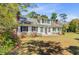 Charming two-story home with white siding, black shutters, mature trees, and landscaped front yard at 1300 S Main St, Summerville, SC 29483