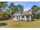 Charming two-story home with white siding, black shutters, mature trees, and manicured lawn at 1300 S Main St, Summerville, SC 29483