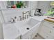 Close-up of farmhouse sink with bronze faucet, and white countertops in the kitchen at 1300 S Main St, Summerville, SC 29483