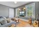Comfortable living room with a plush gray sofa, hardwood floors, and natural light from two windows at 1300 S Main St, Summerville, SC 29483