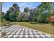 Spacious checkered tile patio surrounded by lush landscaping and mature trees at 1300 S Main St, Summerville, SC 29483