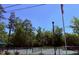 Outdoor pickleball courts surrounded by lush trees and an American flag under a clear blue sky at 1300 S Main St, Summerville, SC 29483