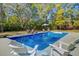 A backyard pool is surrounded by chairs and greenery at 1300 S Main St, Summerville, SC 29483